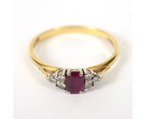 A RUBY AND DIAMOND 18 CARAT GOLD RING  the oval cut with a trio of small brilliant cuts to each shoulder, totalling approxima