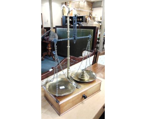 A SET OF AVERY BRASS SCALES AND WEIGHTS on mahogany platform base with drawer, the scales 66cm high overall, the base 41cm wi