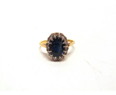 A SAPPHIRE & DIAMOND 18 CARAT GOLD CLUSTER RING  the oval cut sapphire enclosed by twelve single cut diamonds, finger size L,