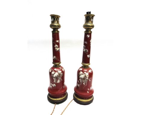 A PAIR OF LARGE EDWARDIAN BRASS MOUNTED TABLE LAMP BASES  the ceramic bodies decorated with vine leaves, on ebonised oak base