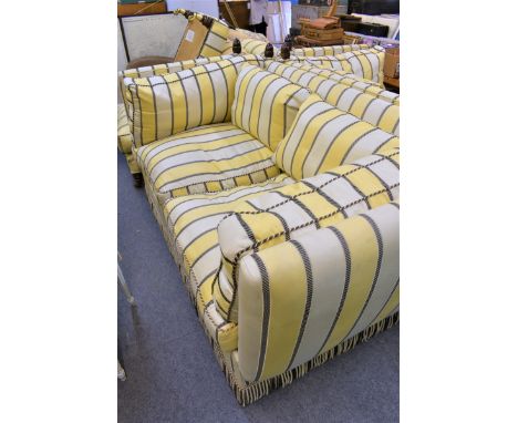 A Knowle style sofa with matching footstool in a striped pale yellow upholstery. 