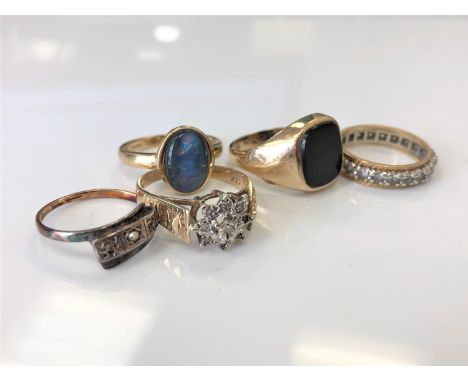 A 9ct gold triplet opal ring, a 9ct gold and silver eternity ring, a 9ct gold black onyx signet ring, a 9ct gold cluster ring