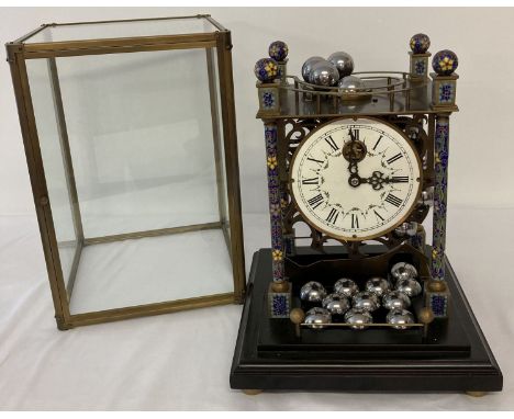 A skeleton movement rolling ball table clock with cloisonné posts and finials.  Hand painted enamelled face with Roman Numera