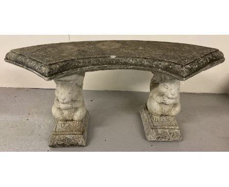 A concrete ornamental garden bench with curved seat and squirrel pedestal supports.   Approx. 44cm tall x 99cm long.