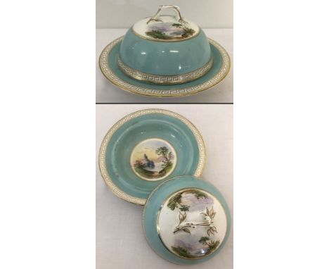 An Antique ceramic muffin dish with hand painted scenes to inside dish and lid.  Gilt Greek key design to border and branch s