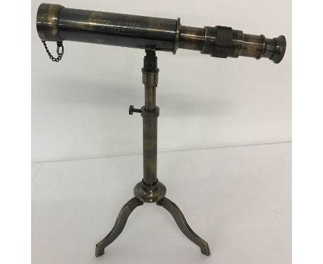 A small brass telescope mounted on an extending tripod base with folding feet.  Telescope body is marked "W Ottway &amp; Co L