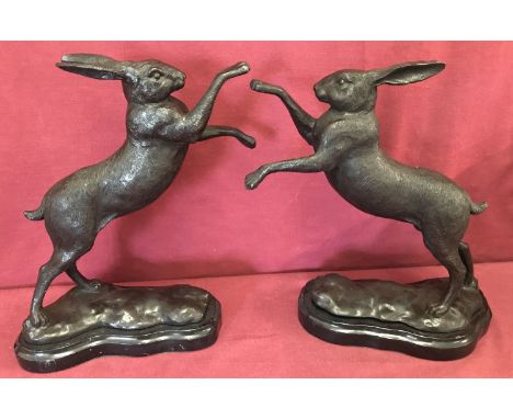 A pair of bronze "boxing hares" figurines mounted on marble bases.   Approx. 29cm tall.