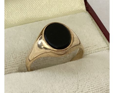 A 9ct gold signet ring set with an oval onyx stone. Full hallmarks to inside of band.  Ring size P.  Total weight approx. 2.7