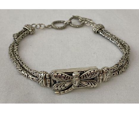 A decorative double strand silver bracelet with central panel decorated with dragonfly detail.  Pierced work to back of panel