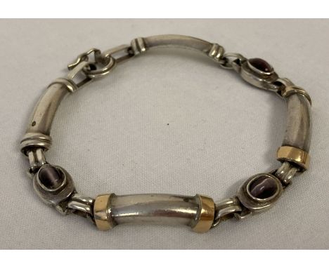 A modern design silver and 18ct gold panel bracelet set with 3 purple agate cabochon stones.  With unusual circular clasp wit
