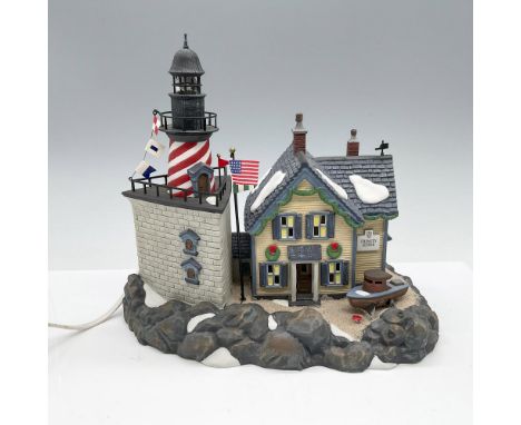 This hand-decorated porcelain figurine depicts a seaside lighthouse and the keepers house. This item has its original box whi