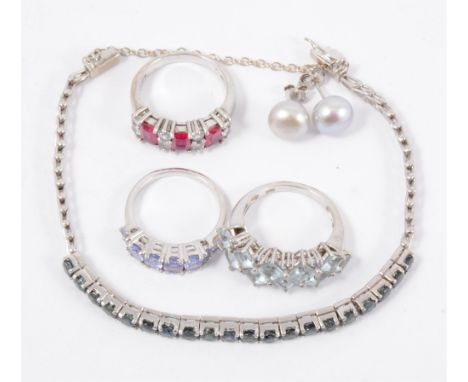 A collection of silver and white metal jewellery, a tanzanite half hoop ring, a ring with aqua coloured stones, another with 