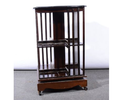 Edwardian mahogany revolving bookcase, serpentine top with a moulded edge, slatted sides, plinth base with bracket feet, on c