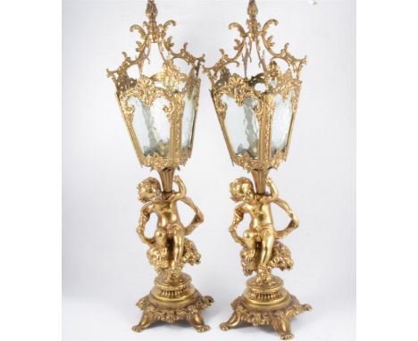 Pair of reproduction gilt metal mantel lanterns, each modelled with a cherub, the lanterns of square section with frosted pan