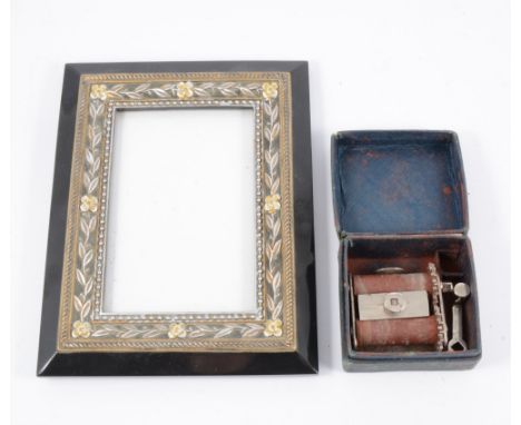 A contemporary rectangular picture frame aperture 5.5x3.5", floral border, easel back, and a cigarette roller, (2).