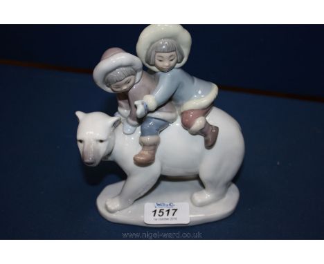 A Lladro figure of a Polar Bear with two Eskimo on it's back, 7'' tall.