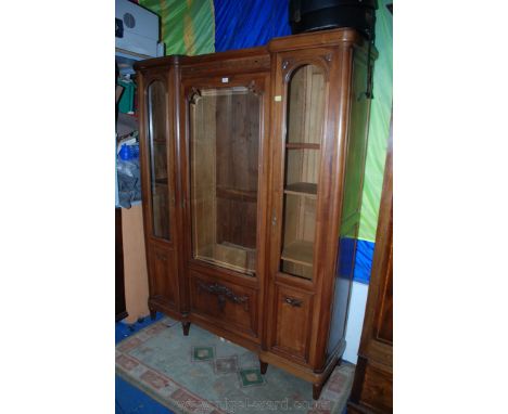 A French Walnut glazed Display Breakfront Cabinet having moulded cornice over central Aztec style carved frieze, over the cen