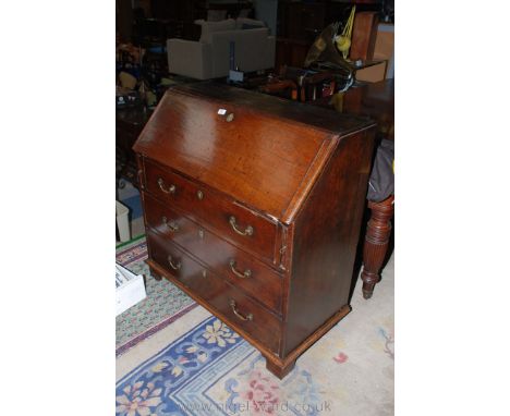 A Georgian Oak Bureau having plain top over the cleated edge moulded fall opening to reveal four pigeon holes over two rows o