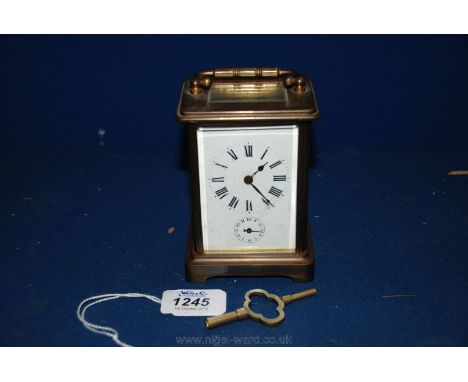 A French brass and bevel plate glass cased Carriage Clock with white Roman numeral face and clockwork movement, with key.  