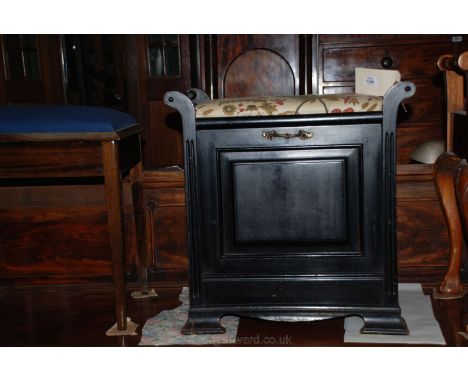 An Art Nouveau ebonised Music Stool having turned handles in scroll supports, cream ground stylized floral fabric applied sea