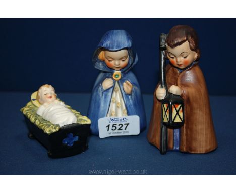 Three Goebel figures of Mary, Joseph and baby Jesus in a crib.