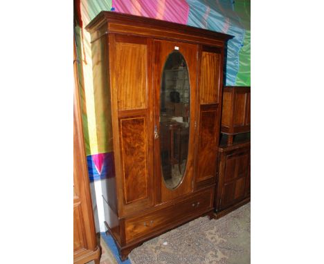 An Edwardian Mahogany single door Wardrobe with moulded cornice over the central single door featuring oval bevel plate mirro