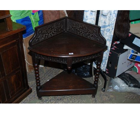 A late 19th c. Oak Corner Table with floral carved upstand back, the bow front top having moulded edges on a carved frieze, s