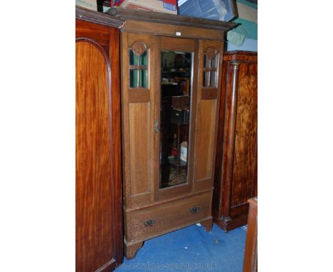 An Arts & Crafts Oak single door Wardrobe with moulded cornice over plain frieze, central rectangular bevel plate mirrored do