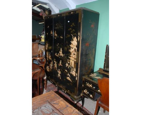 A circa 1900 Chinoiserie lacquer decorated Triple door Wardrobe having pair of opposing and single doors, the left door openi