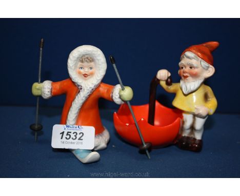 Two unusual Goebel figures: a Skier with long red coat and with poles and a Gnome with an open upside down umbrella.