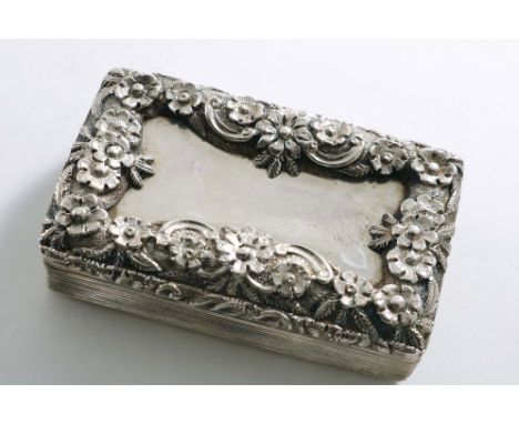 A WILLIAM IV RECTANGULAR SNUFF BOX with reeded sides on engine-turned base and raised floral borders on the cover around a va