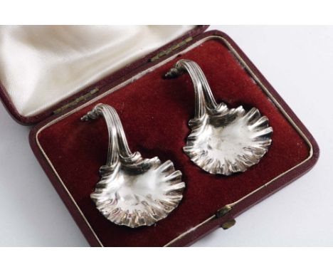 A LATE VICTORIAN CASED PAIR OF CAST CADDY SPOONS with scallop shell bowls and reeded scroll handles, by J.B. Carrington, Lond
