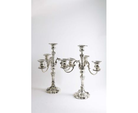 A PAIR OF LATE VICTORIAN / EDWARDIAN FOUR-LIGHT CANDELABRA on shaped circular bases, decorated with scrolls &amp; flowers and