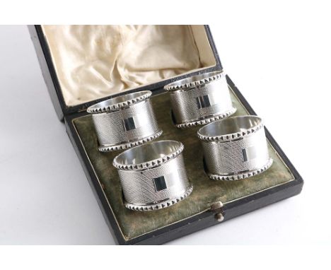 A CASED SET OF FOUR ENGINE-TURNED NAPKIN RINGS with knurled borders, by C.J. Vander Ltd., Birmingham 1973 with a special mark
