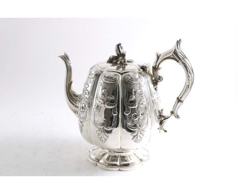 A VICTORIAN IRISH TEA POT on a domed &amp; lobed circular foot with a lobed body &amp; a flower bud finial, the sides embosse