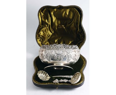A LATE VICTORIAN BOAT-SHAPED SUGAR BASIN with embossed decoration, a pierced rim and a gilt interior, together with a matchin