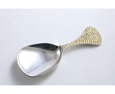 A LATE 20TH CENTURY PARCELGILT CADDY SPOON with a shovel bowl and a flaring handle, decorated with "punched" texturing, by Ri