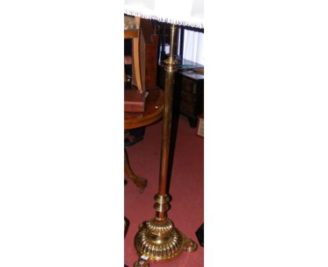 An adjustable brass standard lamp on tripod supports