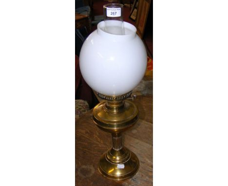 A brass oil lamp with milk glass shade