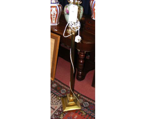 A brass Corinthian column adjustable standard lamp on Lion's paw feet, complete with shade
