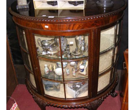 A Maple & Co. 1920's mahogany half round display cabinet on carved ball and claw supports