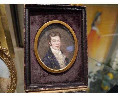 Portrait miniature of a young gentleman, c. 1820, dressed in a brass-buttoned blue coat, watercolour on ivory, in a fitted le