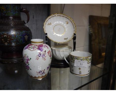 A Derby porcelain tea bowl and saucer, early 19th century, wrythen and moulded, decorated with gilt sprigs, on an ebonised st