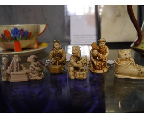 Collection of Japanese ivory netsuke including Beijin kneeling with hand mirror, cat within boot and father and son with frog