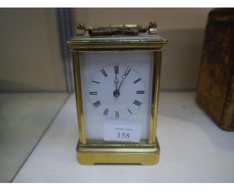 Early 20th century gilt-brass carriage clock, the white enamel dial with Roman numerals, with key. 