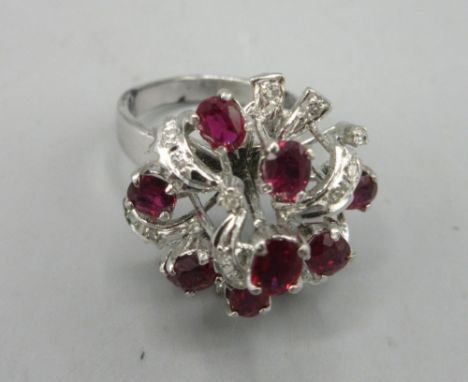 18ct white gold cocktail ring set with nine rubies and brilliant cut diamonds, stamped 18, size N, 7.7g
