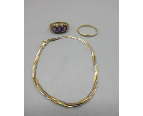 9ct yellow gold ring set with three purple stones in an ornate mount, a 9ct yellow gold band ring, a 9ct multi tone gold brac