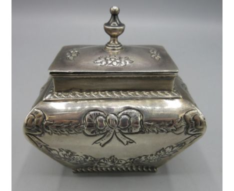 Victorian silver tea caddy in baluster form, rectangular hinged lid with urn finial, body decorated with foliate and bow swag