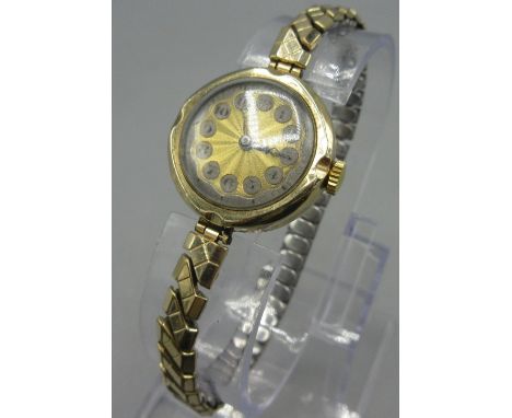 9ct yellow gold watch engine turned dial with Arabic numerals, Swiss made 14 Jewel movement,  on gold plated expanding strap