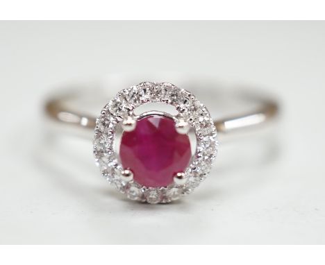 A modern 18ct white gold, ruby and diamond set circular cluster ring, size M, gross weight 3.1 grams.